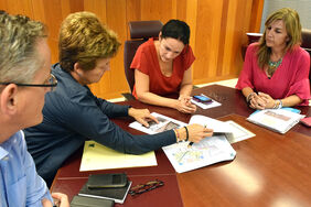 Zaida González y Aymara Calero revisan la documentación del solar durante la reunión