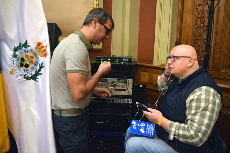 El concejal Carlos Correa sigue las instrucciones del técnico para acceder al sistema para personas con deficiencias auditivas instalado hoy en el Ayuntamiento de Santa Cruz.