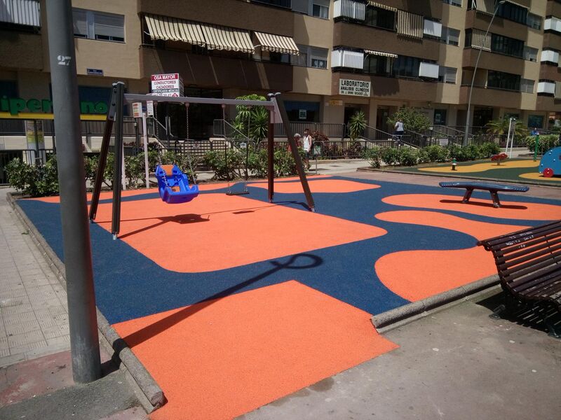 Detalle de las mejoras incorporadas en una de las zonas infantiles de la plaza de Los Sabandeños, con nuevo pavimento amortiguador y la instalación de un columpio adaptado.