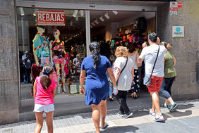 Varios viandantes se disponen a entrar en un comercio de la calle Castillo durante el primer domingo de las rebajas estivales en Santa Cruz.