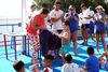 Carmen Delia Alberto hace entrega de un diploma a uno de los participantes en los cursillos de natación de la Piscina Municipal Acidalio Lorenzo.