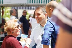 El alcalde departe con una asistente a la Feria de Vacaciones, en la plaza del Príncipe