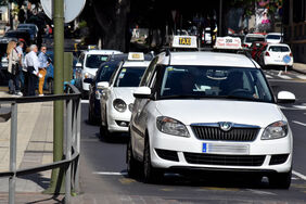 Varios taxis circulan por una calle de Santa Cruz.