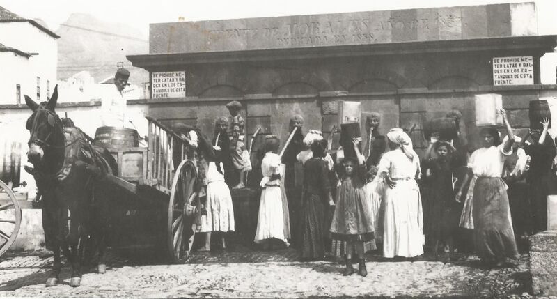 Mujeres y niñas, con el ruedo en la cabeza para soportar el peso de los recipientes con agua, en una imagen de 1920